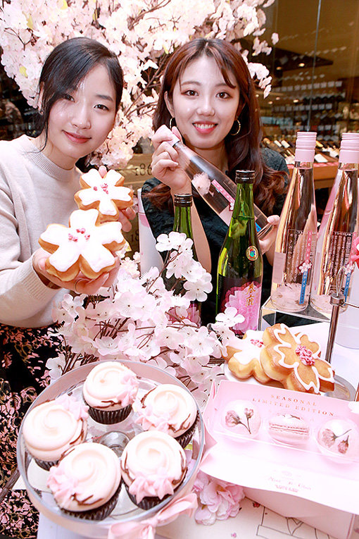 본격적인 벚꽃 시즌을 맞아 유통업계 테마로 ‘벚꽃엔딩’이 뜨고 있다. 현대백화점 직원들이 4일 압구정본점 식품관에서 벚꽃을 테마로 한 디저트를 선보이고 있다. 사진제공 l 현대백화점