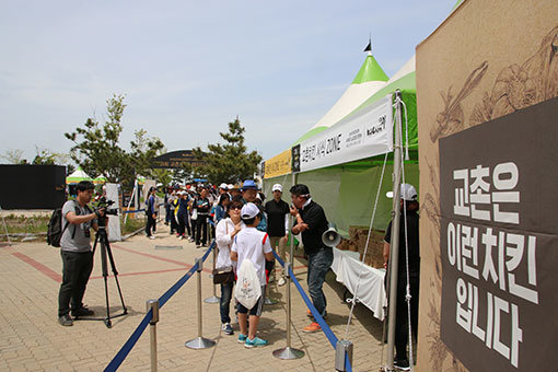 가족 단위 갤러리들이 골프장에 마련된 교촌치킨 시식 존에서 치킨을 맛보고 있다.