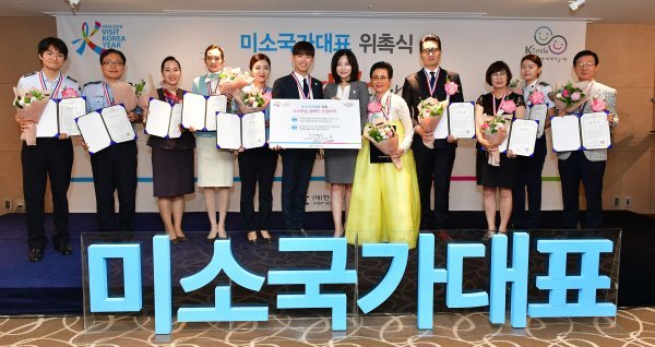 관광접점 우수종사자들과 기념촬영을 하는 에릭남(왼쪽에서 여섯번째)과 한경아 한국방문위 사무국장.