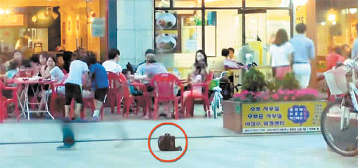 한국의 치안 수준을 실험하기 위해 명동 길바닥에 놓인 카메라 가방. 수많은 행인들은 이 가방에 관심을 갖지 않았고, 가방은 안전히 실험자의 품으로 돌아갔다. 사진출처|유튜버 TV화인문 화면캡처