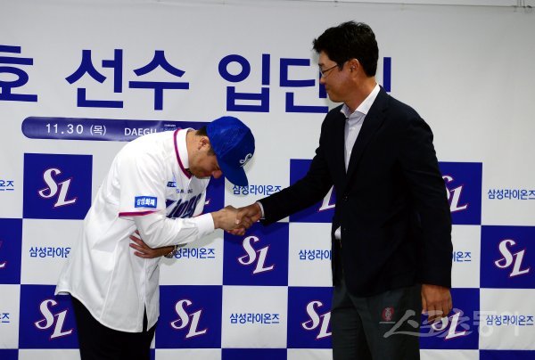 30일 대구 라이온즈파크에서 4년 총액 80억에 FA 계약한 삼성 강민호의 입단식이 열렸다. 강민호가 김한수 감독으로부터 모자를 받은 뒤 악수를 나누고 있다. 대구 | 김민성 기자 marineboy@donga.com
