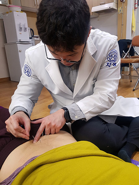 자생한방병원 의료진이 진료소를 방문한 근골격계 환자에게 침 치료를 실시하고 있다. 사진제공|자생한방병원