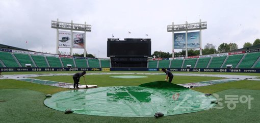 19일 서울 잠실야구장에서 열릴 예정이던 ‘2019 신한은행 MY CAR KBO리그’ NC 다이노스와 LG 트윈스의 경기가 우천으로 인해 취소가 됐다. 구장 관계자들이 그라운드를 정비하고 있다. 잠실｜김진환 기자 kwangshin00@donga.com
