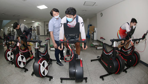 광명스피돔에 설치된 와트바이크를 타며 실내훈련을 하고 있는 신은섭, 정해민, 조영환 선수(오른쪽부터)와 그들을 지도하고 있는 김영호 안전지원관. 사진제공｜국민체육진흥공단