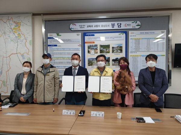 김기용 봉담읍장(오른쪽에서 3번째)과 이삭훈련소 둥글개봉사단 이웅종 단장(왼쪽에서 3번째)이 업무협약을 체결한 뒤 기념촬영에 응하고 있다. 
사진제공 l 화성시청