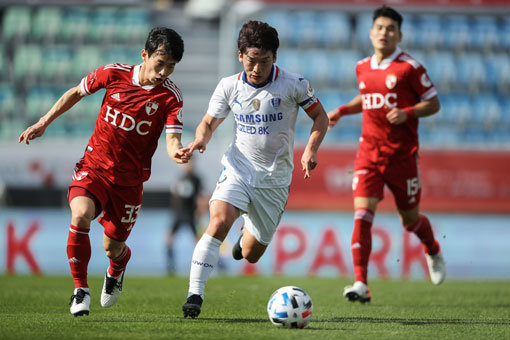 부산 김문환(왼쪽)과 수원 김민우. 사진제공｜한국프로축구연맹