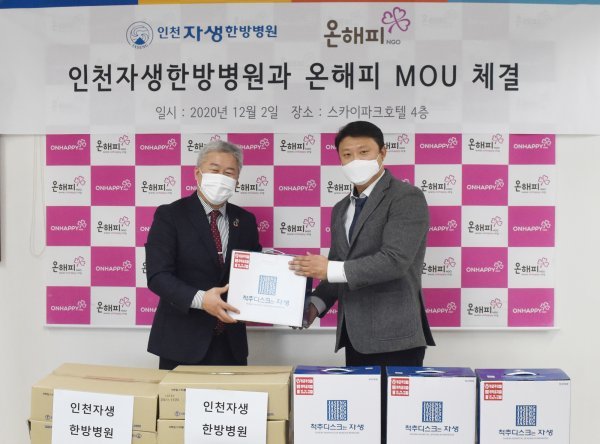 인천자생한방병원 장진욱 행정실장(오른쪽)이 온해피 배인식 회장에게 취약계층 노인들을 위한 쌍화탕과 한방파스를 전달하고 있다.