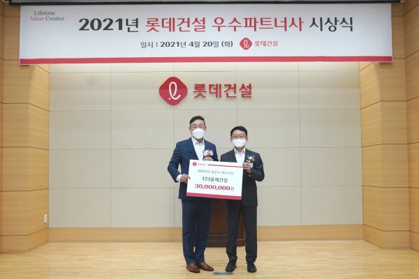 롯데건설 하석주 대표(오른쪽)가 최우수 파트너사로 선정된 ㈜올레건설 최영복 대표와 기념 촬영을 하고 있다. 사진제공 | 롯데건설