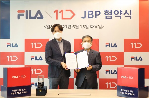 윤근창(왼쪽) 휠라코리아 대표와 이상호 11번가 사장이 협약식 후 기념 촬영을 하고 있다. 사진제공 l 11번가