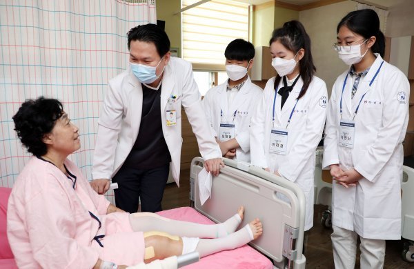 지난해 실시한 힘찬병원 청소년 여름 인턴십에서 참여 학생들이 의사와 함께 회진을 돌고 있다.