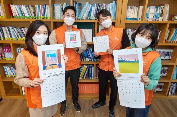 한화 점자달력 제작 21주년을 맞아 한화봉사단 임직원들이 점자달력을 소개하며 기념촬영 하고 있다. 사진제공 한화