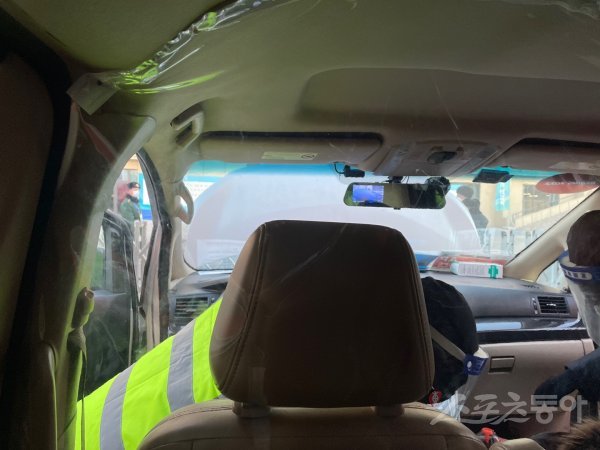 1일 베이징 캐피털 실내빙상장에서 보안요원들이 방역택시의 운전석과 조수석을 수색하고 있다. 활짝 열려있는 후드(보닛)가 눈에 띈다. 베이징｜강산 기자