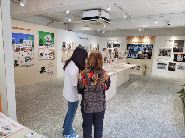 한화가 성수동 카페골목에서 개최한 ‘독수리협동조합’의 전시회 모습. 전시회를 찾은 관람객이 직원으로부터 설명을 듣고 있다. 사진제공 | 한화 이글스