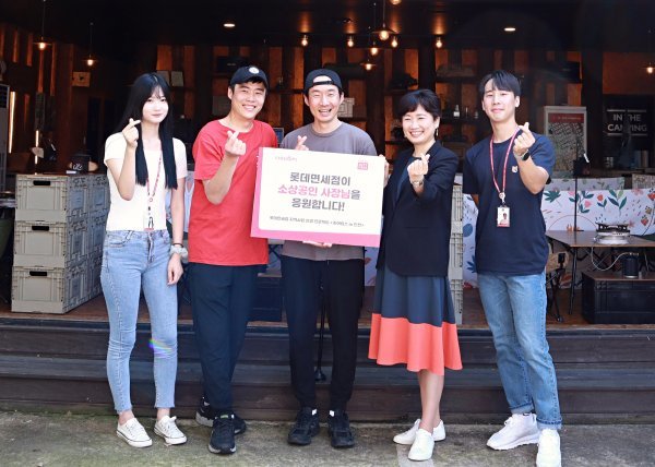 이상진 롯데면세점 마케팅부문장(왼쪽 네 번째)과 소상공인 대표(왼쪽 두 번째와 세 번째), 치어러브 대학생 서포터즈들이 기념촬영을 하고 있다.