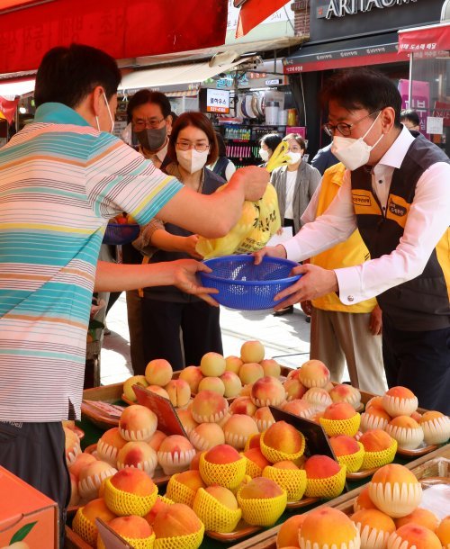 서울 동작구 남성사계시장에서 과일을 사고 있는 이재근 KB국민은행장. 사진제공 l KB국민은행