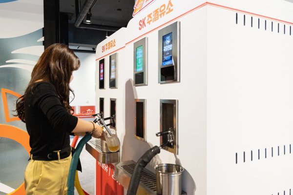 SK 주(酒)유소에서 고객이 주유기 콘셉트의 디스펜서에서 맥주를 잔에 담고 있다. 사진제공｜SK에너지