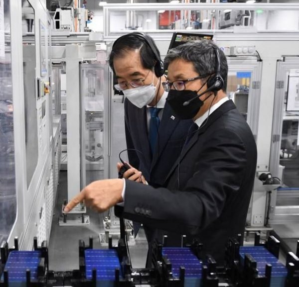 16일 (현지시각) 미국 조지아 달튼 한화큐셀 공장에서 한덕수 국무총리(왼쪽)에게 최병용 한화큐셀 달튼 공장장이 자동화된 생산라인을 소개하고 있다. 사진제공｜한화솔루션