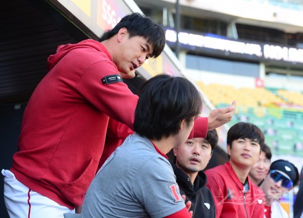 23일 인천 SSG랜더스필드에서 열린 KBO리그 SSG 랜더스와 두산 베어스의 연습경기에서 SSG 김광현이 최정과 김성현에게 겨울에 추운 이유에 대해 설명하고 있다. 인천 | 주현희 기자 teth1147@donga.com