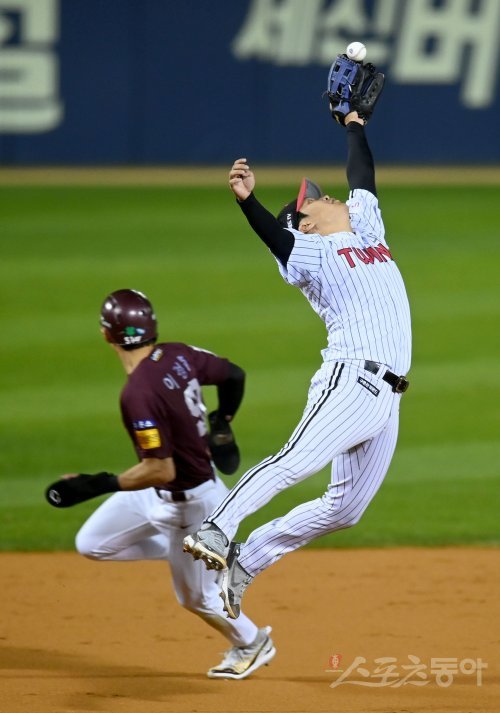 LG 문보경(오른쪽)은 24일 잠실구장에서 벌어진 키움과 PO 1차전에서 공수에 걸친 맹활약으로 팀의 6-3 승리를 이끌었다. 3회초 2사 2·3루서 김혜성의 뜬공 타구를 가까스로 잡아내고 있는 문보경. 잠실 | 김종원 기자 won@donga.com