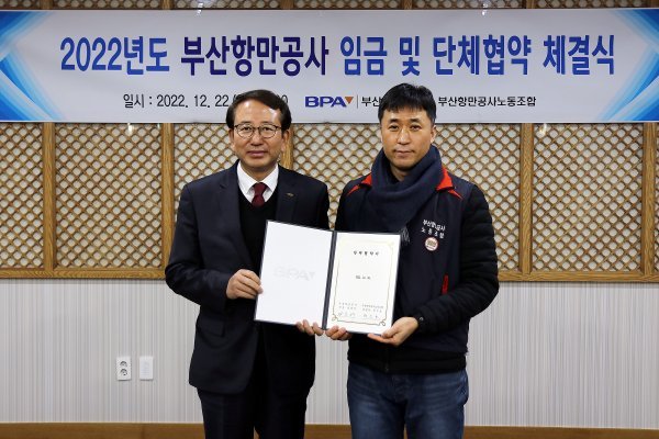 부산항만공사 노사가 지난 22일 본사 사옥에서 2022년도 임금·단체협약을 체결한 가운데 강준석 사장(왼쪽)이 박신호 노조위원장(오른쪽)과 기념 촬영을 하고 있다. 사진제공 | 부산항만공사