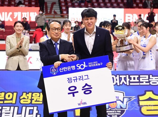 13일 부산사직종합운동장 실내체육관에서 열린 ‘신한은행 SOL 2022~2023 여자프로농구‘ 부산 BNK와 아산 우리은행의 경기에서 76-52로 우승을 확정지은 우리은행 위성우 감독이 이병완 WKBL 총재와 기념 촬영을 하고 있다. 사직 | 주현희 기자 teth1147@donga.com