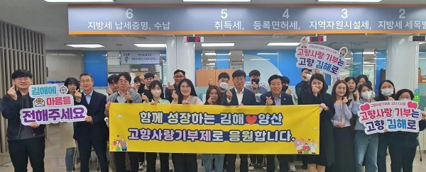 김해시와 양산시의 직원들이 고향사랑기부제 상호 기부에 동참한 가운데 관계자들이 기념촬영을 하고 있다. 사진제공ㅣ김해시