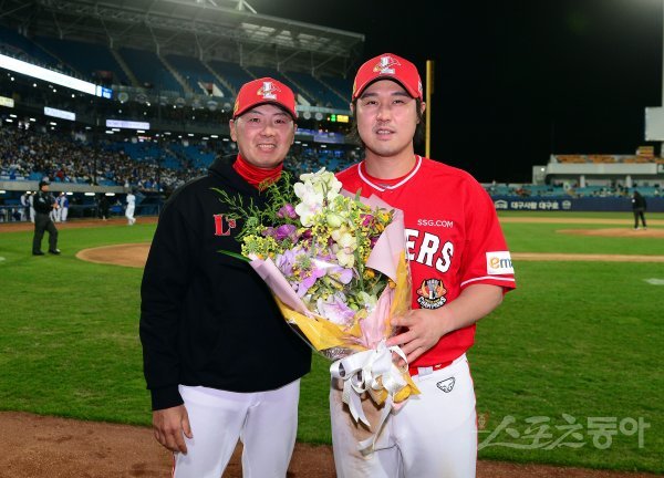 SSG 김원형 감독(왼쪽)이 개인통산 2000안타의 대기록을 달성한 최정에게 축하 꽃다발을 건넨 뒤 기념촬영을 하고 있다. 대구 | 김민성 기자 marineboy@donga.com
