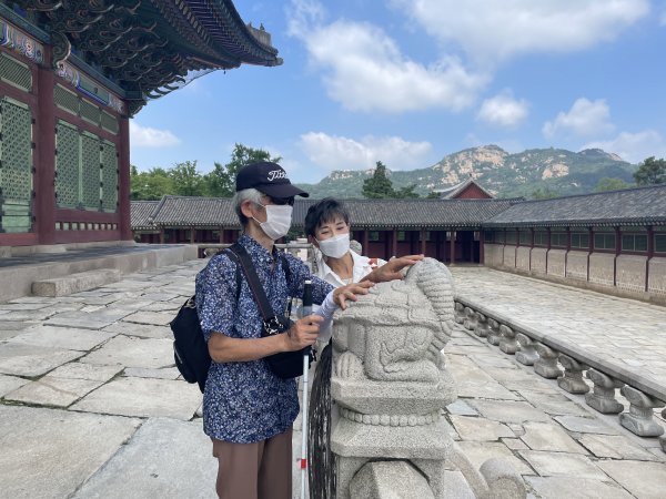 서울관광재단 현장영상해설사의 해설을 들으며 해치를 만져보는 시각장애인 관람객