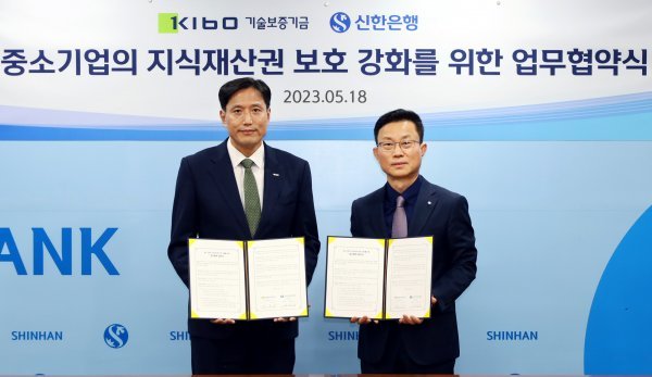 기술보증기금이 지난 18일 신한은행과 서울 중구 소재 신한은행 본점에서 ‘중소기업의 지식재산권 보호 강화를 위한 업무협력 협약’을 체결한 가운데 박주선 기보 이사(왼쪽)가 김윤홍 신한은행 부행장과 기념촬영을 하고 있다. 사진제공ㅣ기술보증기금