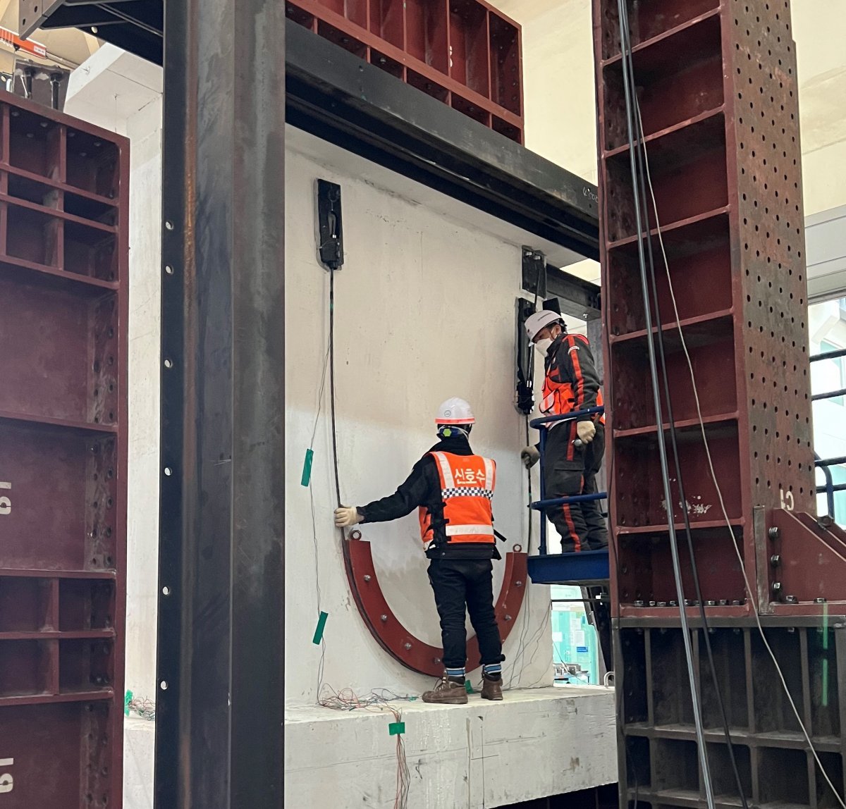 DL이앤씨 직원들이 수직증축 리모델링의 안전성 문제를 해결할 수 있는 ‘포스트텐션 하중전이공법’을 국내 건설업계 최초로 개발해 검증하고 있다. 사진제공 ｜ DL이앤씨