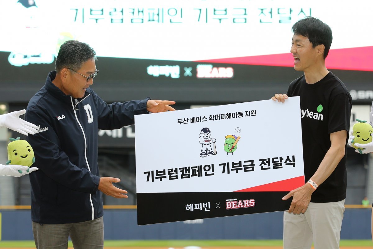 두산 선수단과 팬이 참여형 기부 캠페인 ‘기부럽’을 통해 모은 6030만 원은 학대피해 아동의 심리 치료를 지원하는 데 쓰일 예정이다. 20일 잠실 SSG전에 앞서 열린 약정식에 참석한 전풍 두산 베어스 사장(왼쪽)과 유봉석 해피빈재단 대표. 사진제공 | 두산 베어스
