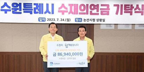 이재준 수원시장(왼쪽)이 백성현 논산시장에게 성금을 전달하고 있다. 사진제공|수원시