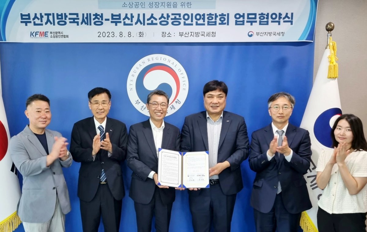 부산지방국세청이 지난 8일 부산시 소상공인연합회와 업무협약을 체결한 가운데 장일현 청장(왼쪽 세 번째)과 최송희 연합회장(왼쪽 네 번째)이 관계자들과 기념촬영을 하고 있다. 사진제공ㅣ부산지방국세청