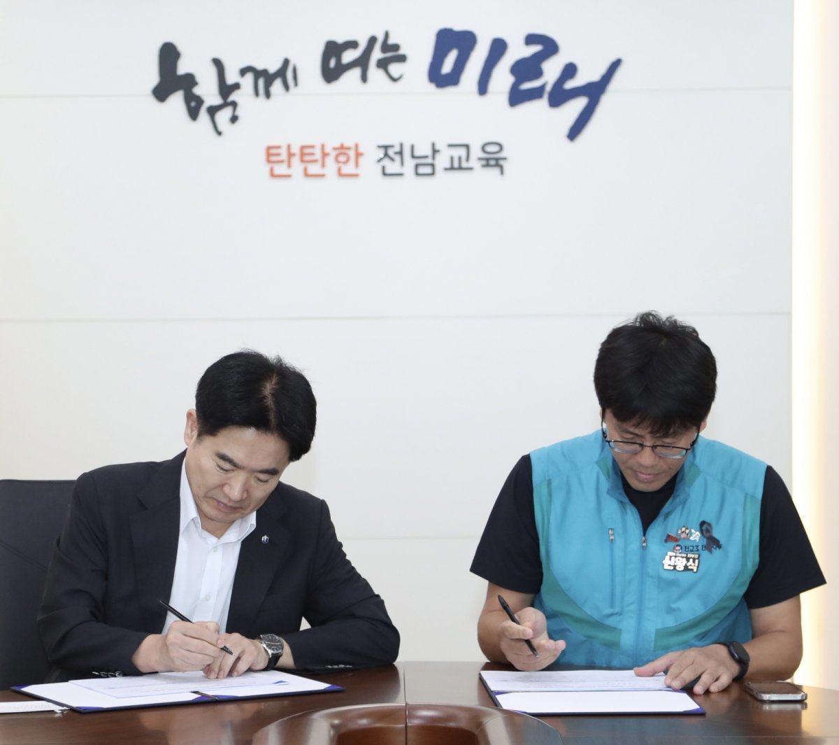 김대중 전남도교육감(좌측)과 신왕식 전교조전남지부 지부장이 9일 상반기 정책협의회 체결식에서 합의서에 서명하고 있는 모습. 사진제공ㅣ전남도교육청