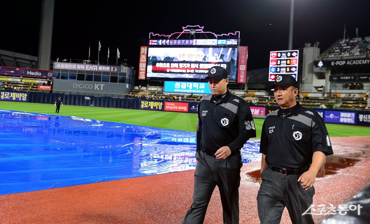 5일 경기도 수원 kt위즈파크에서 ‘2023 신한은행 SOL KBO리그’ kt 위즈와 LG 트윈스의 경기가 열렸다. 4회초 무사에서 갑작스런 폭우에 경기가 중단 후 비가 그치자 심판들이 그라운드를 살펴보고 있다. 수원 | 김민성 기자 marineboy@donga.com