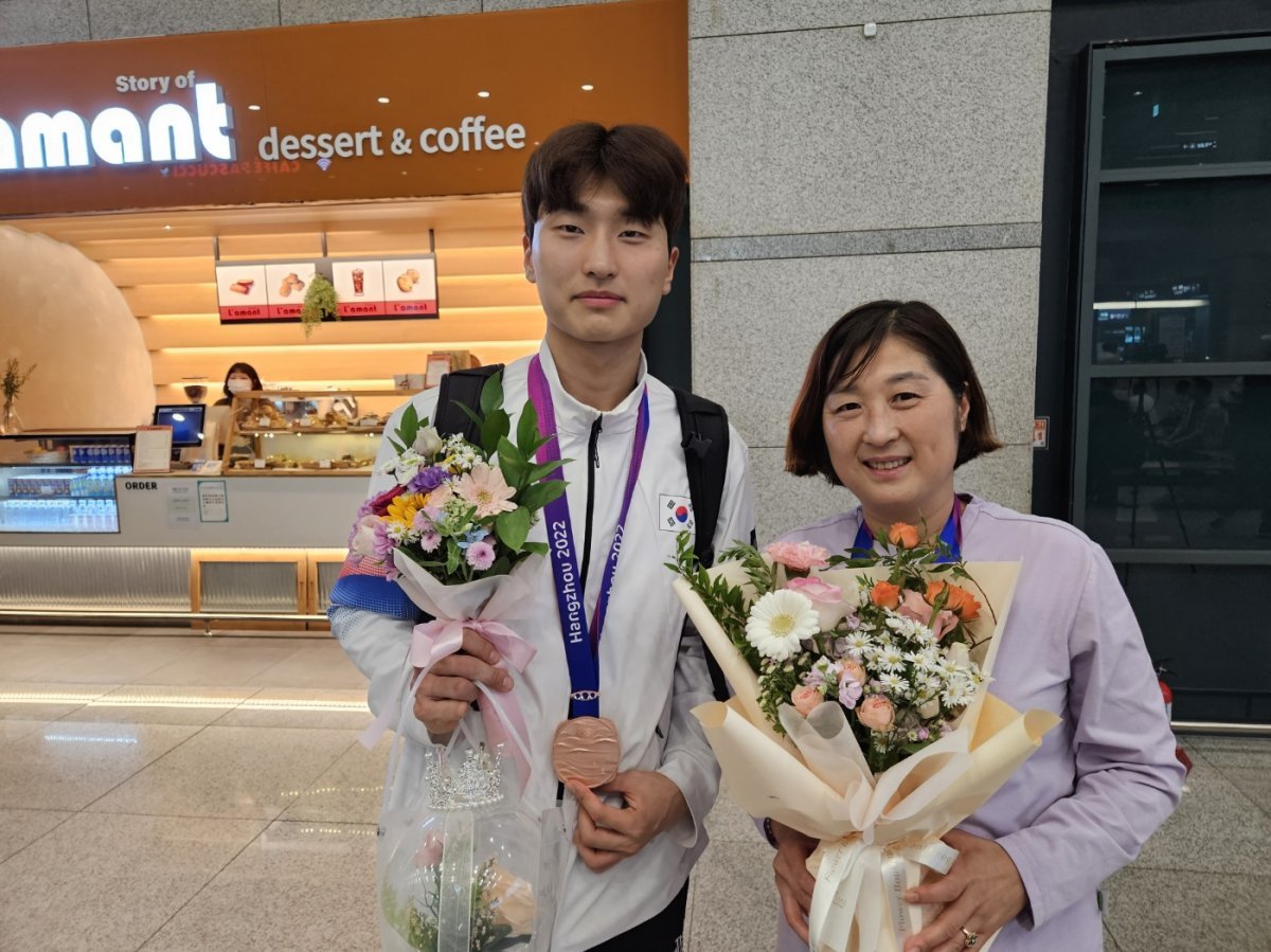 길영아 삼성생명 감독(오른쪽)은 과거 유수의 국제대회에서 메달을 목에 건 한국배드민턴의 레전드다. 2022항저우아시안게임에선 아들 김원호(왼쪽)가 남자단체전 동메달과 남자복식 은메달을 가져오며 ‘모자 메달리스트‘가 됐다. 내심 2024파리올림픽에서도 아들이 메달을 목에 걸길 바라는 마음이다. 항저우아시안게임 이후 귀국해 기념촬영하고 있는 길영아-김원호 모자. 사진제공 | 삼성생명 배드민턴단