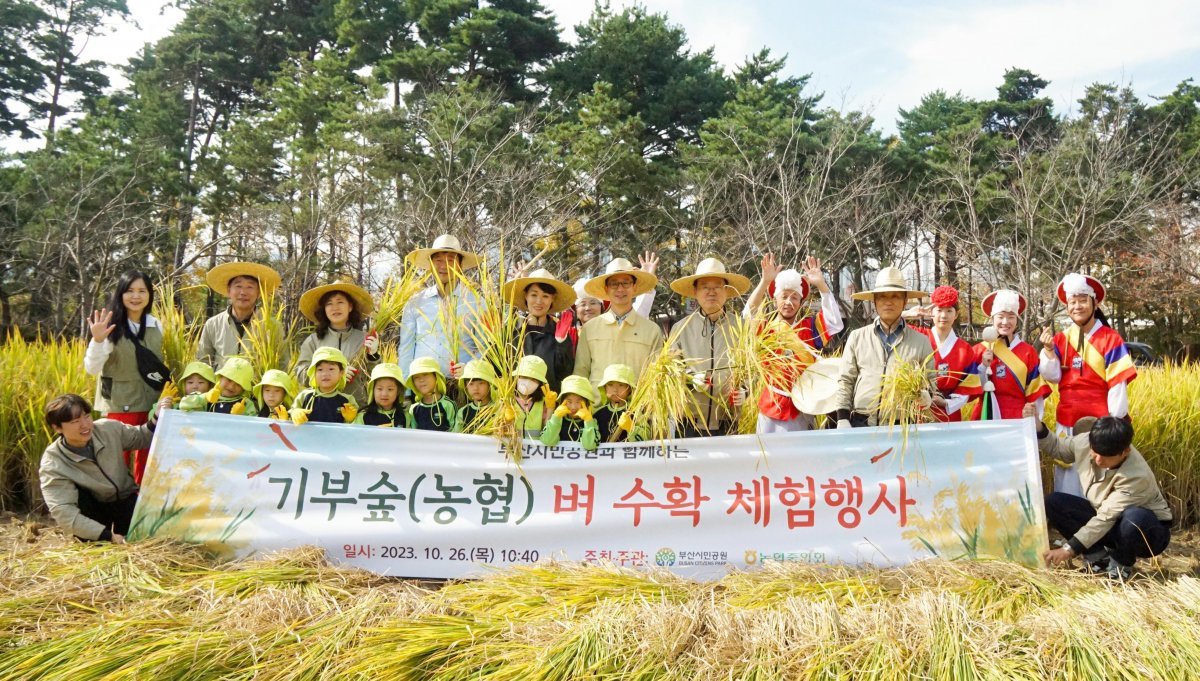 부산시설공단이 26일 오전 부산시민공원 기부숲 텃논에서 제4회 벼 수확 체험행사를 개최한 가운데 관계자들이 기념촬영을 하고 있다. 사진제공ㅣ부산시설공단