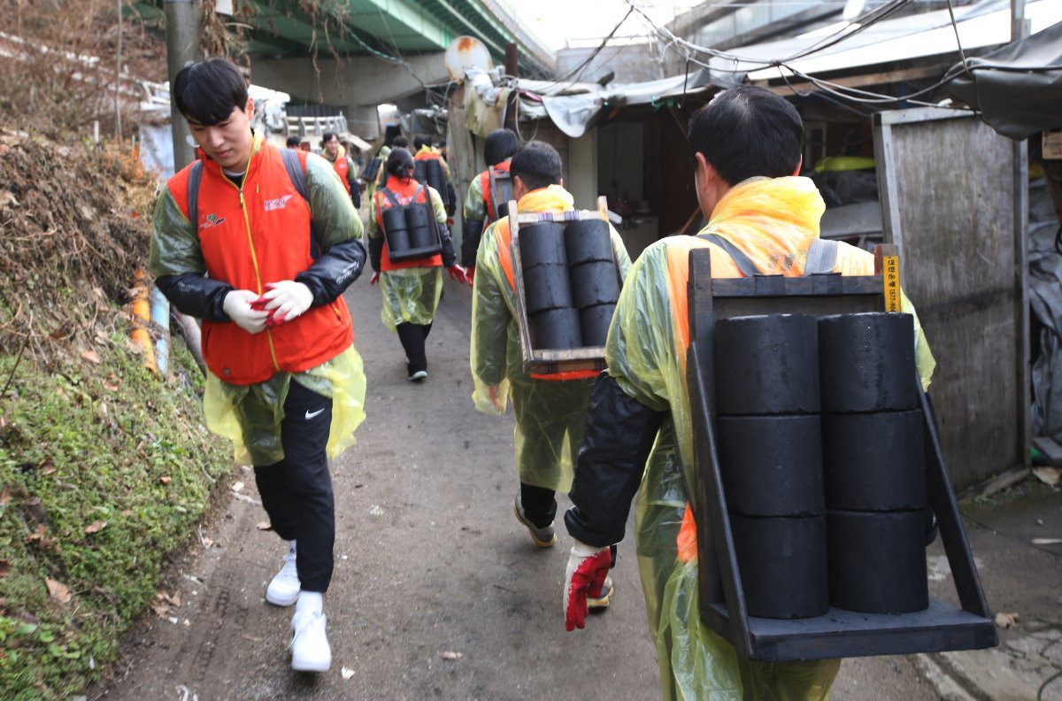 연탄 나눔 봉사활동 참여자들이 광명스피돔 인근 에너쥐 취약 가구에 월동생활을 위한 연탄을 나르고 있다.