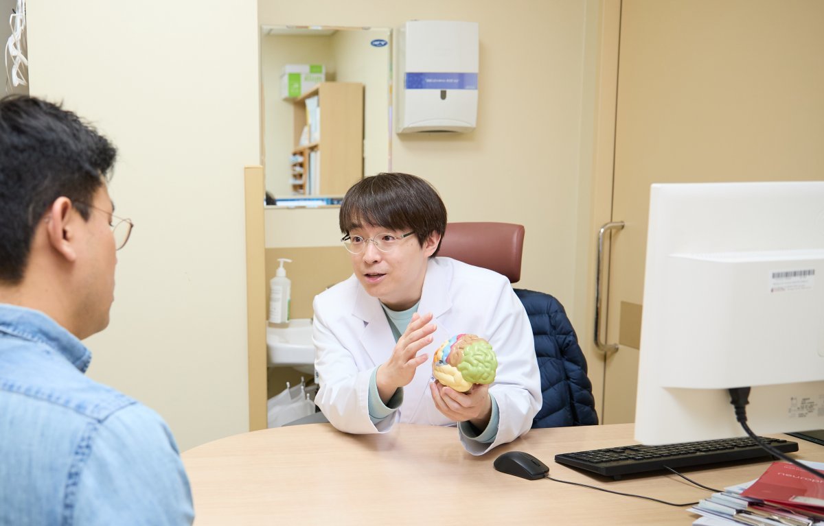 고려대 구로병원 신경과 강성훈 교수가 초로기 치매 의심환자에게 질병에 대해설명하고 있다.