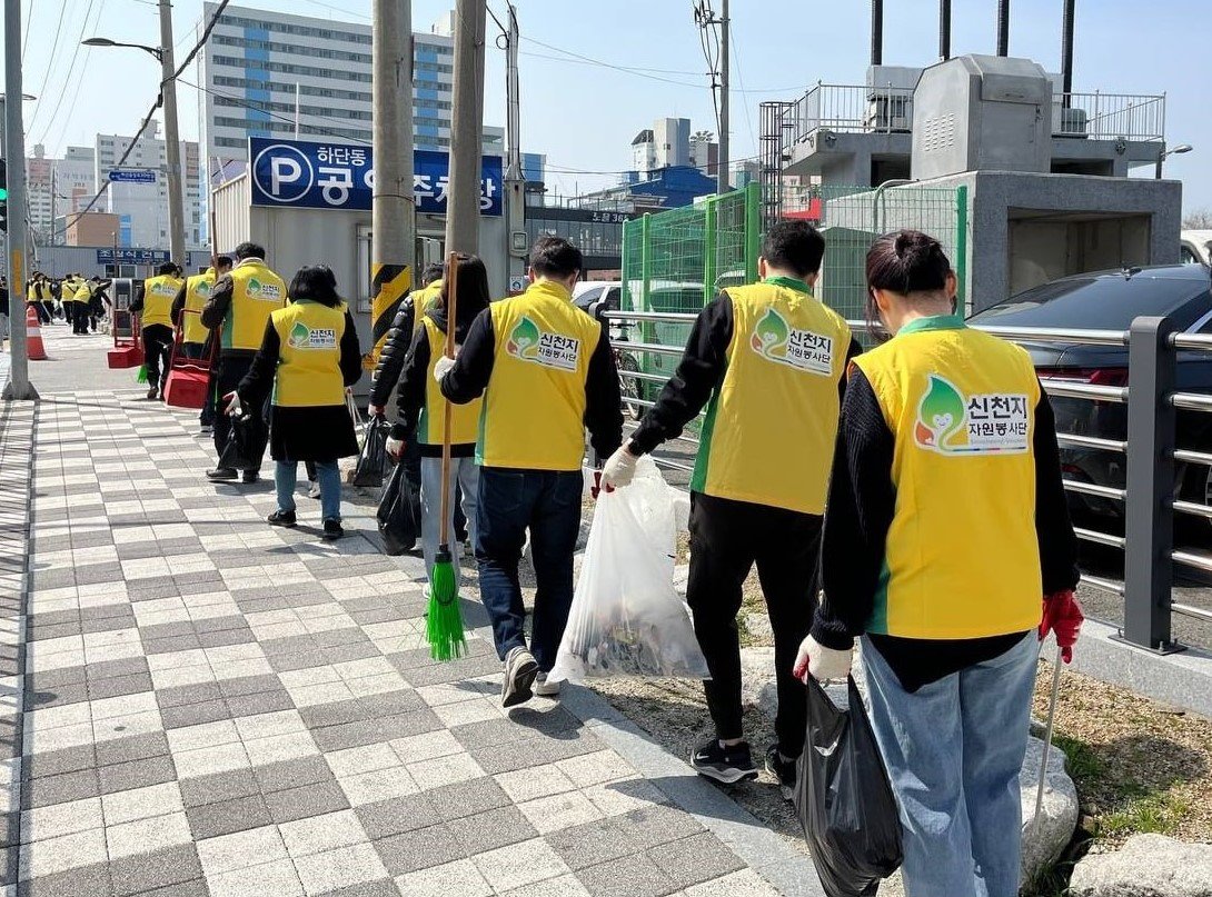 신천지 부산교회가 23일 사하구에 위치한 하단성전 일대에서 ‘클린하단’ 캠페인을 진행한 가운데 봉사자들이 쓰레기를 수거해 줄지어 이동하고 있다. 사진제공 | 신천지 부산교회