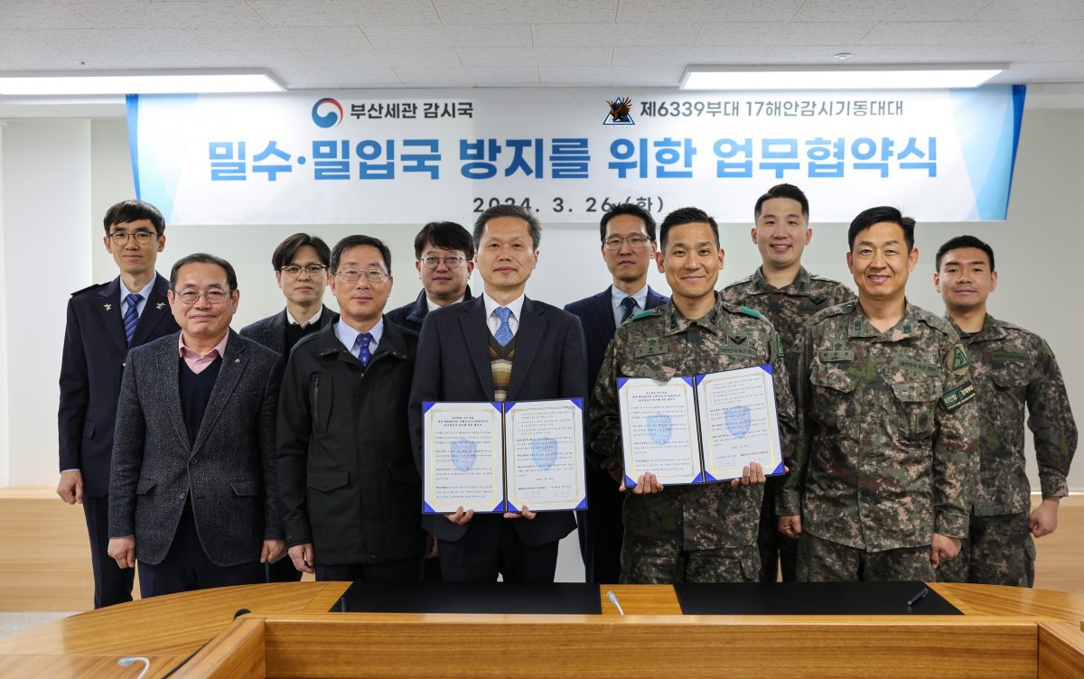 부산본부세관이 지난 26일 본관에서 육군 부산 여단 17해안감시기동대대와 ‘밀수·밀입국 방지를 위한 업무협약’을 체결한 가운데 관계자들이 기념촬영을 하고 있다. 사진제공 | 부산본부세관