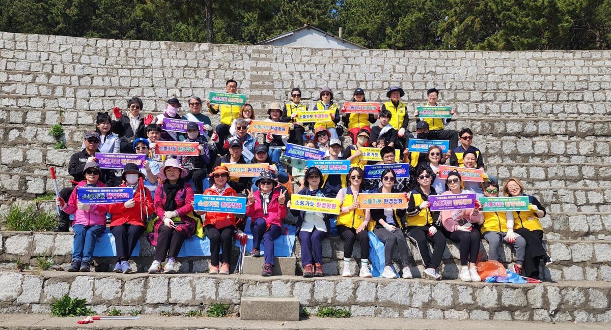 한국미용문화봉사회가 지난 7일 부산 남구 이기대 어울마당 주변에서 봄맞이 해양쓰레기 정화활동을 펼친 가운데 관계자들이 ‘소풍가듯 환경정화’ 팻말을 들고 기념촬영을 하고 있다. 사진제공|한국미용문화봉사회