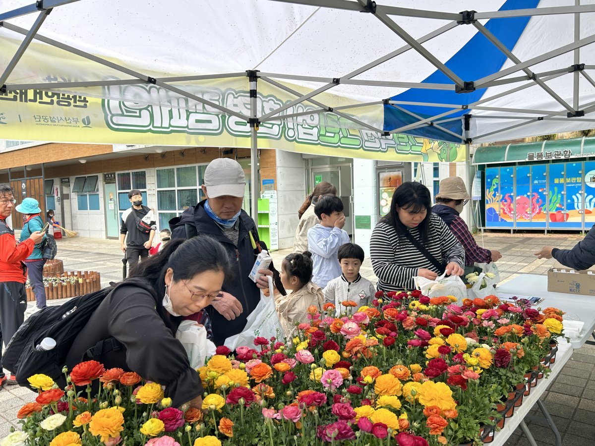 지난 21일 어린이대공원 찾은 가족이 환경캠페인에 참여한 후 초화를 고르고 있다. 사진제공｜부산시설공단