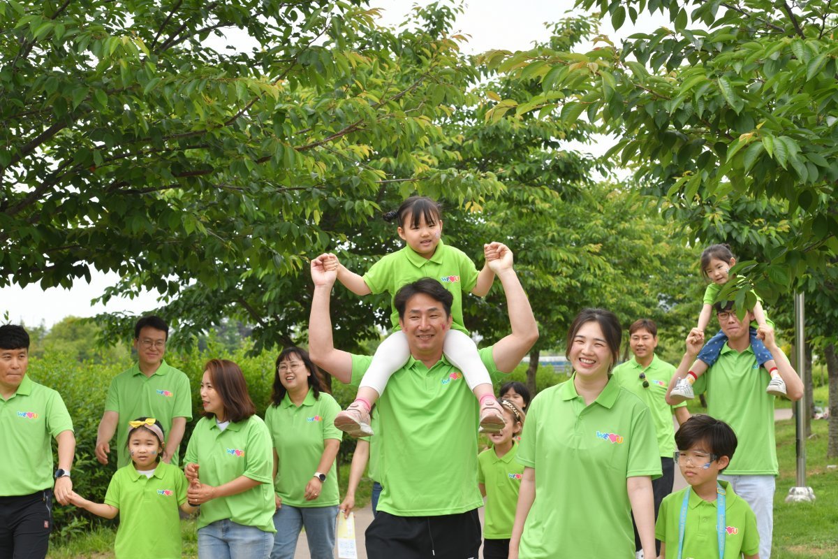 어린 딸을 목말 태운 아빠와 가족 단위 참가자들이 즐겁게 걷고 있다.