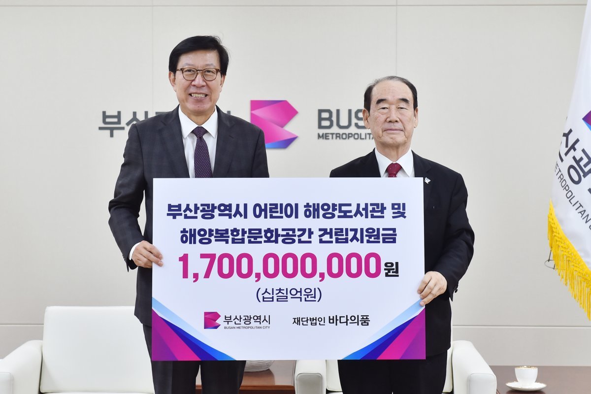 부산시과 바다의품이 지난 28일 시청 의전실에서 ‘어린이 해양도서관·해양복합문화공간 건립 지원금 전달식’을 개최한 가운데 박형준 시장(왼쪽)이 정태순 이사장과 기념촬영을 하고 있다. 사진제공 | 부산시