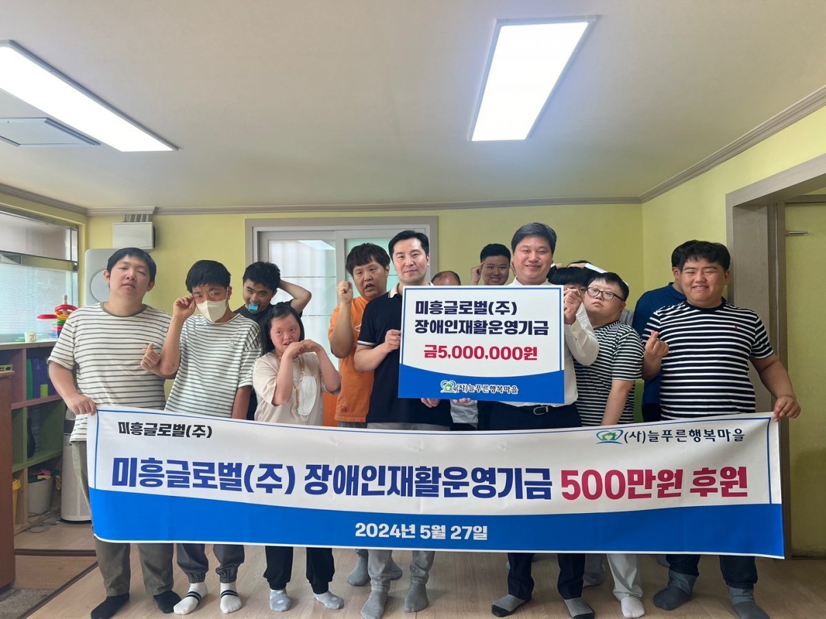 (주)미흥글로벌이 장애인 시설인 늘푸른행복마을을 방문해 후원금을 기탁하고 기념촬영을 하고 있다.