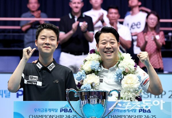 강동궁(오른쪽)이 24일 열린 ‘우리금융캐피탈 PBA 챔피언십’ 결승전에서 ‘고교생 특급’ 김영원(왼쪽)을 물리친 뒤 우승 트로피를 앞에 두고 두 사람이 포즈를 취하고 있다. 이번 대회 ‘태풍의 눈’으로 떠오른 김영원은 준우승에 그쳤지만 그의 이름을 프로당구계에 확실하게 각인시켰다. 사진제공 ㅣ PBA