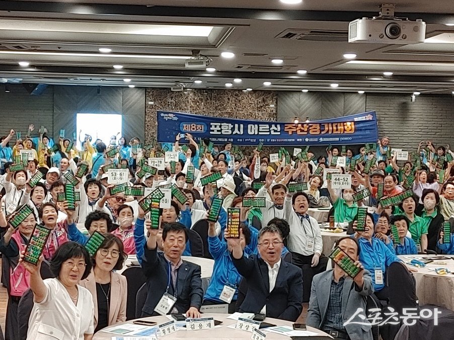 주산대회에 참가한 어르신들이 주판을 들어올리며 화이팅을 외고 있다./사진=포항시