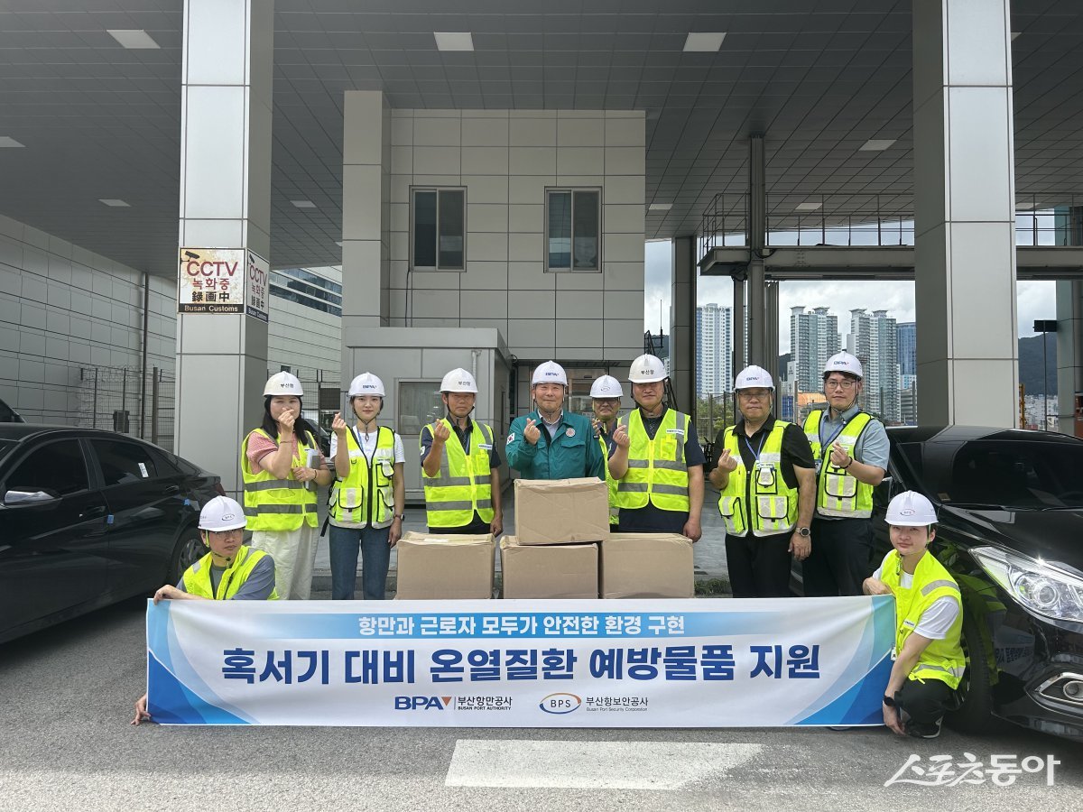 부산항만공사가 지난 22일 여름철 혹서기에 대비해 부산항 현장 근로자들에게 온열 질환 예방물품을 지원한 가운데 관계자들이 기념촬영을 하고 있다. (사진제공=부산항만공사)