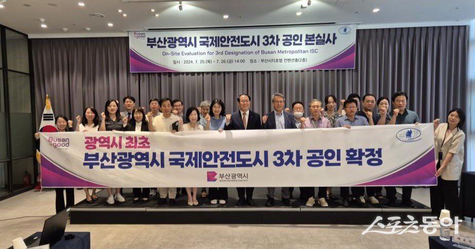 부산시가 광역시 단위로는 최초로 3회 연속 ‘국제안전도시’ 공인을 받은 가운데 관계자들이 국제안전도시 3차 공인 확정을 알리는 현수막을 들고 기념촬영을 하고 있다. (사진제공=부산시)